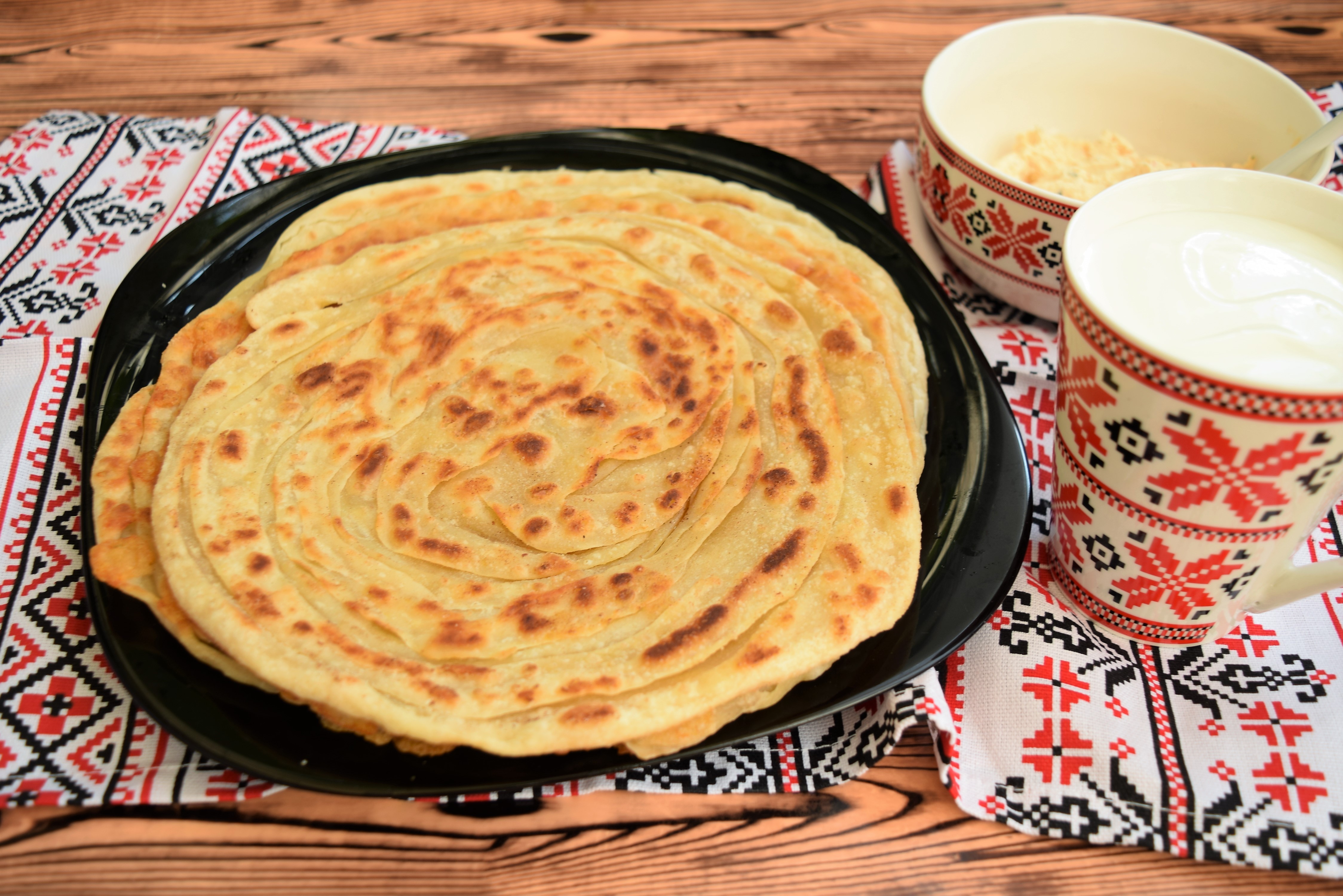 Paratha sau paine plata foietajata preparata la tigaie